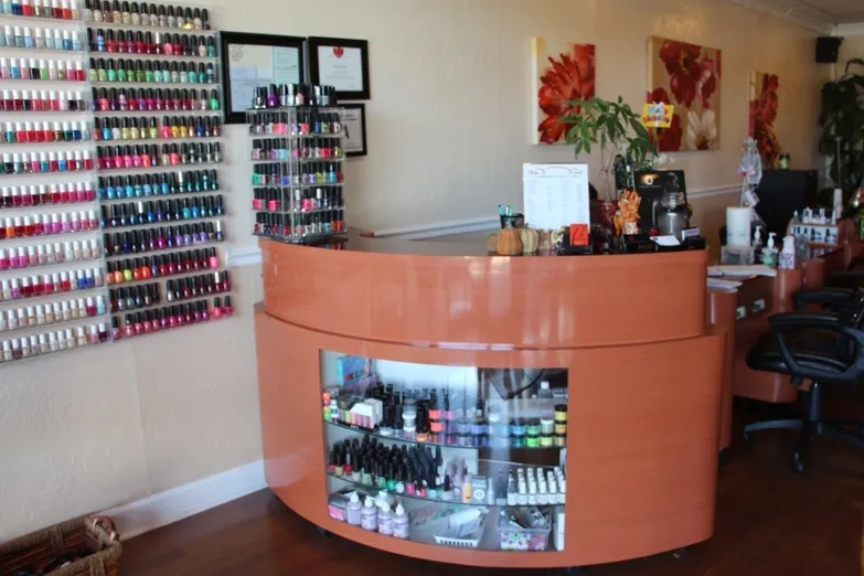 The front desk at Celebration Nails, in front of a wall of polish colors